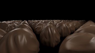 a pile of black chocolate candies on a dark background 