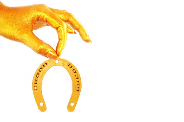 Golden hand holding gold horseshoe — Stock Photo, Image