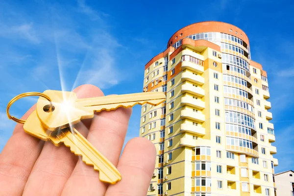 Gouden sleutels met huis op blauwe hemel Stockfoto