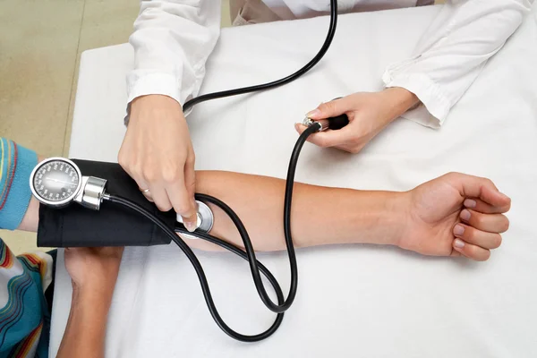 Il medico misura la pressione nel paziente — Foto Stock