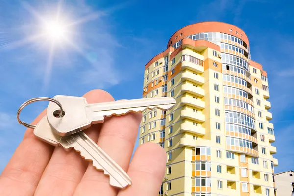Guld nycklar med hus på blå himmel — Stockfoto