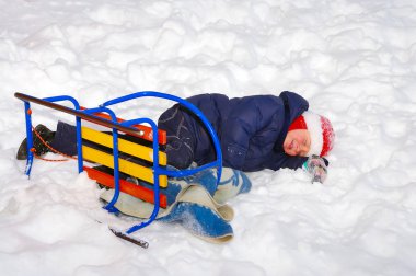children in winter clothes play on the snow in a snow park, winter fun  clipart