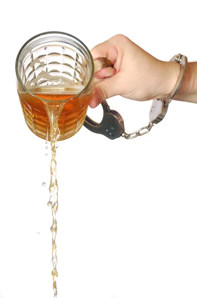 stock image a hand pouring a cup of tea in a glass teapot 