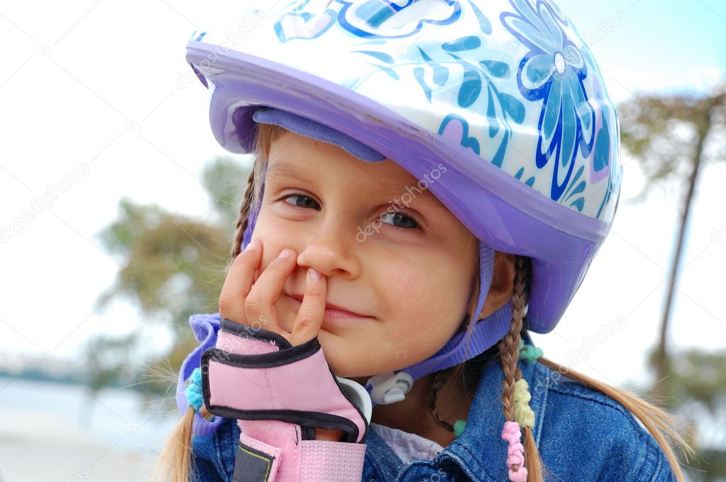 cute little girl in a blue helmet and helmet with a bicycle 
