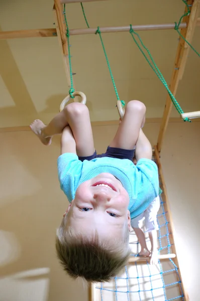 Boy hanging on gymnastic rings — Stock Photo, Image