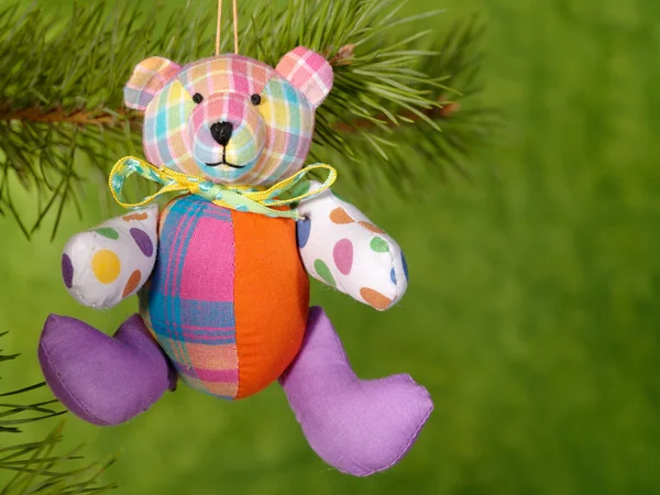 Χριστούγεννα teddybear σχετικά με το πράσινο φόντο. — Φωτογραφία Αρχείου