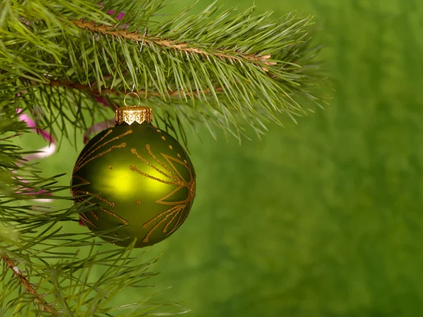 Bola verde de Navidad sobre el fondo verde . —  Fotos de Stock
