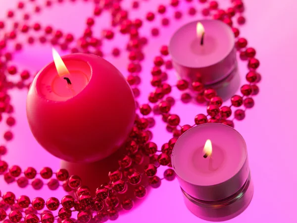 Urlaubsstillleben mit Kerzen auf rosa — Stockfoto