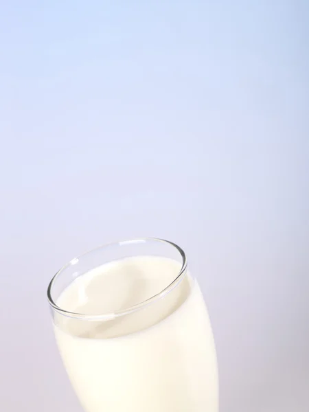 Glas Milch mit blauer Hintergrundbeleuchtung — Stockfoto