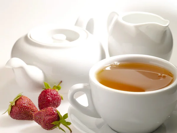 Xícara de chá preto na mesa com louça — Fotografia de Stock