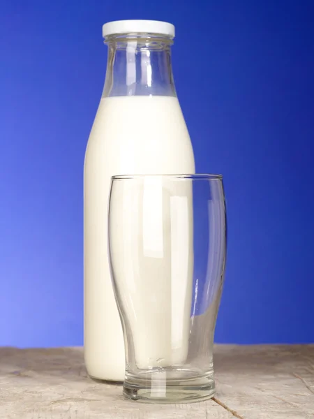 Garrafa com leite fresco e vidro no — Fotografia de Stock