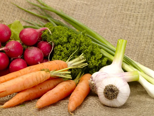 Färska välsmakande grönsaker på säckväv — Stockfoto
