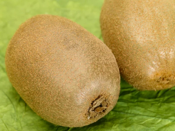 Färska välsmakande kiwifrukt på gröna ba — Stockfoto