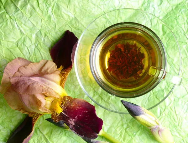 Φλιτζάνι τσάι pf με το λουλούδι στο πράσινο φόντο — Φωτογραφία Αρχείου