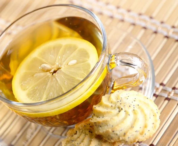 Tee mit Zitronenfrüchten auf Bambus-Hintergrund — Stockfoto