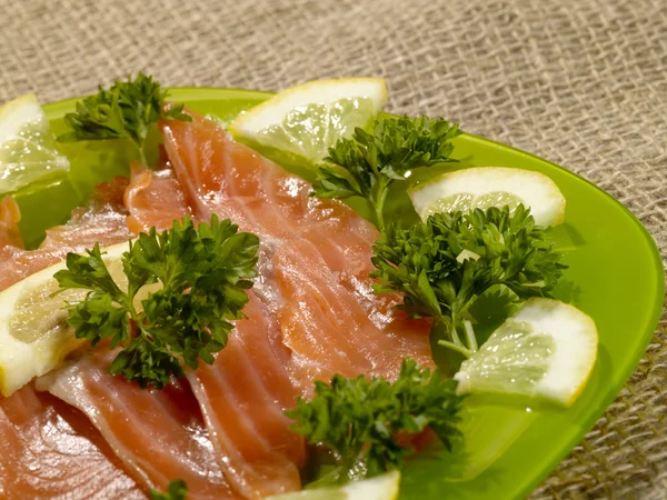 Нарізана риба лосося на зеленій тарілці wi — стокове фото