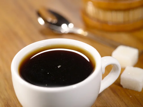 Φλιτζάνι καφέ στο ξύλινο γραφείο με ζάχαρη — Φωτογραφία Αρχείου