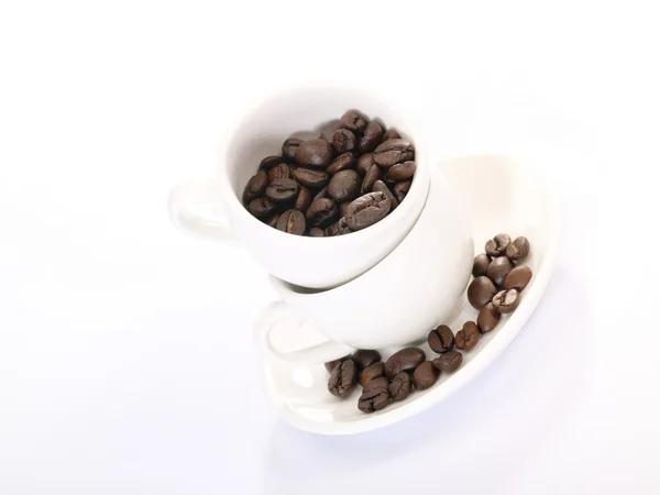 Dwie filiżanki kawy na płytkę z fasoli — Zdjęcie stockowe