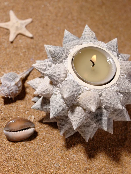 Натюрморт на морском песке со свечой — стоковое фото