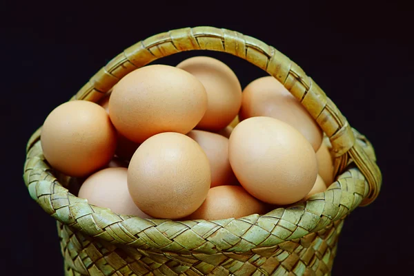 Eggs in a basket on a black background — Stock Photo, Image