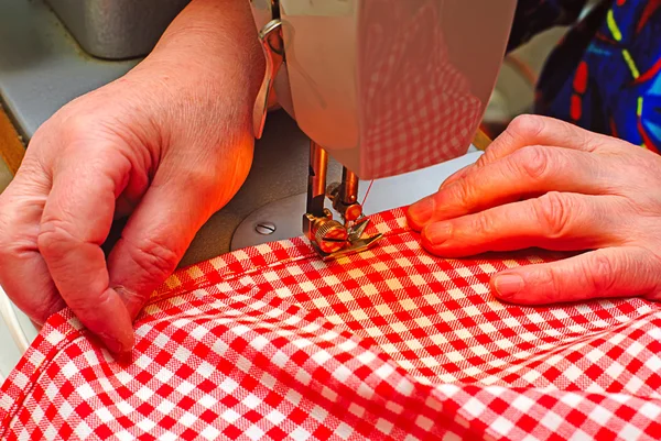 Руки сшивают джинсовую ткань — стоковое фото