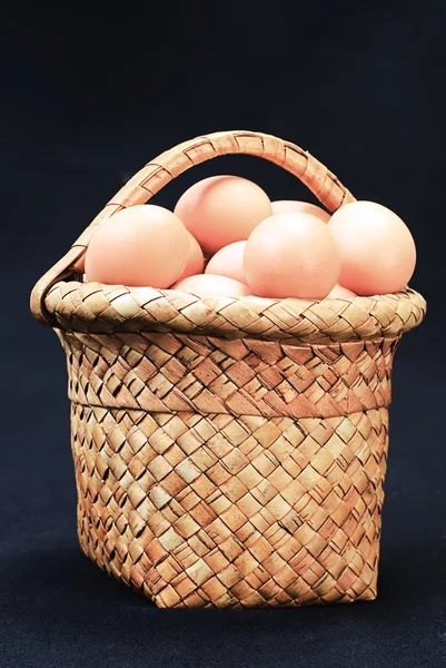 Eggs in a basket on a black — Stock Photo, Image