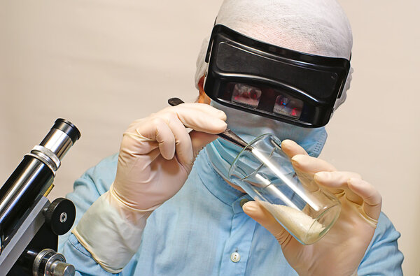 Woman laboratory assistant whit chemical glasses and microscope
