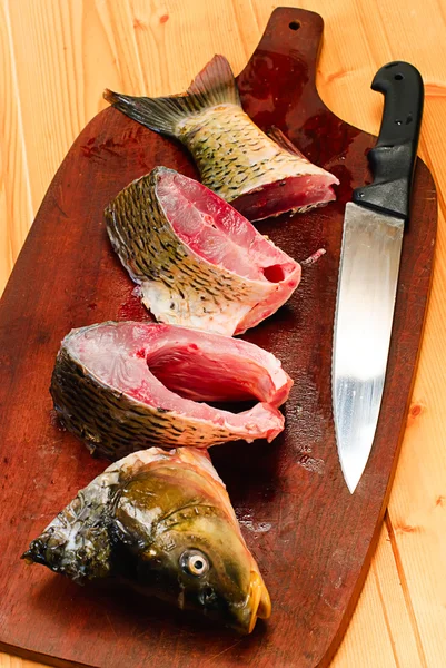 Rå karp fisk på en planka — Stockfoto