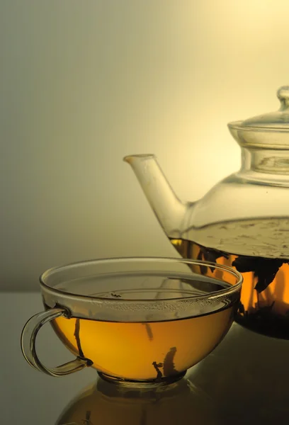 Стеклянный чайник и чашка чая — стоковое фото