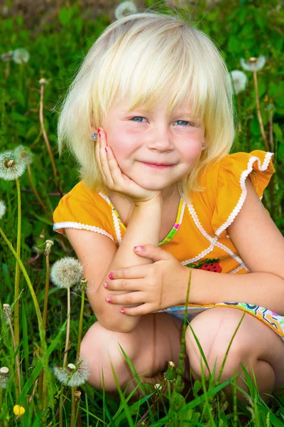 Dandelions arasında küçük bir kız — Stok fotoğraf