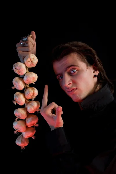 Handsome vampire is not scared by garlic — Stock Photo, Image