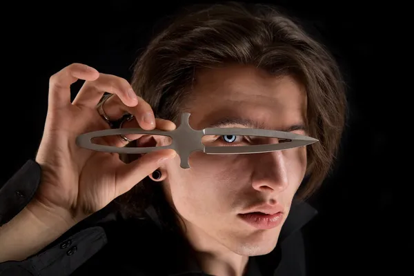 Handsome vampire looking through knife — Stock Photo, Image