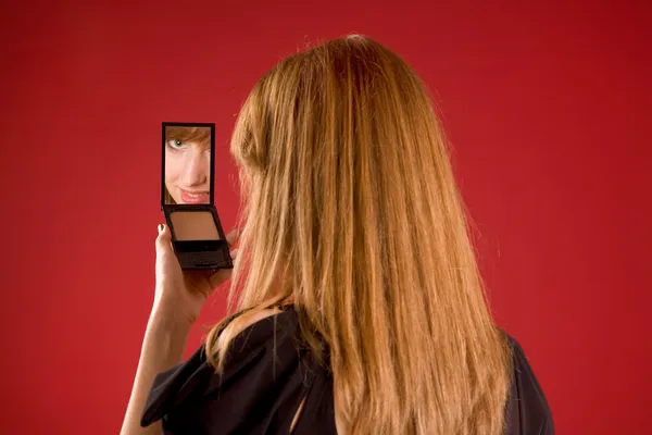 Hermosa chica mirando en el espejo — Foto de Stock