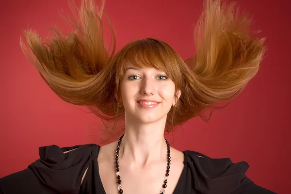 Beautiful red-haired girl shaking her ha — Stock Photo, Image