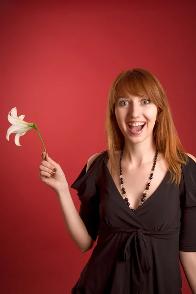Verrast meisje met bloem in de hand — Stockfoto