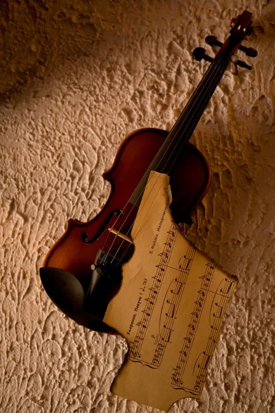 Old violin with burnt music sheet — Stock Photo, Image
