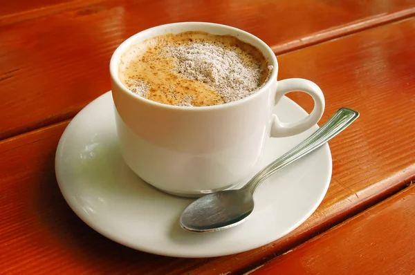 Copo de cappuccino com colher de metal — Fotografia de Stock