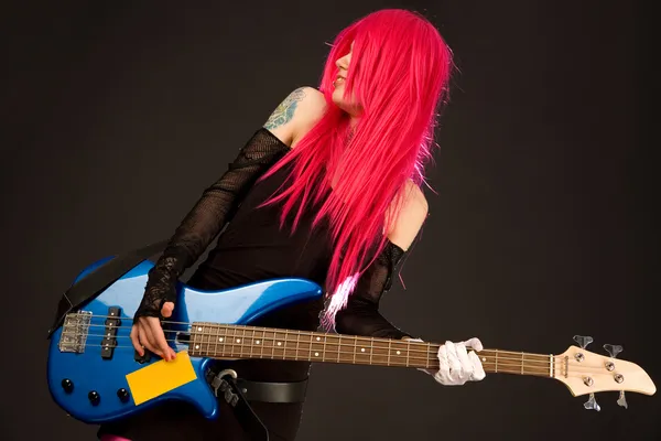 Улыбающаяся панк-девушка с бас-гитарой — стоковое фото
