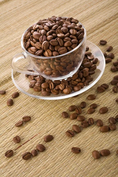 Genomskinlig kopp med kaffe korn — Stockfoto