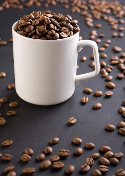Weiße Kaffeetasse mit Kaffeekörnern — Stockfoto