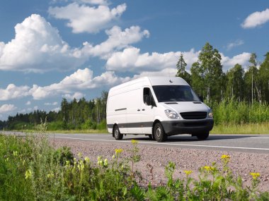 white van on a country road in a summer day  clipart