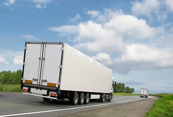 Белые грузовики на шоссе — стоковое фото