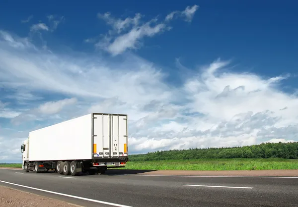 Witte vrachtwagen versnellen weg op snelweg — Stockfoto