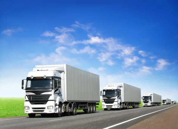 Caravan van witte trucks op highway Rechtenvrije Stockafbeeldingen
