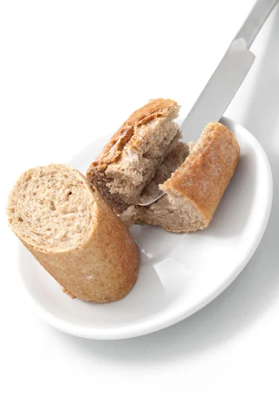 A faca de mesa corta o pão no branco — Fotografia de Stock