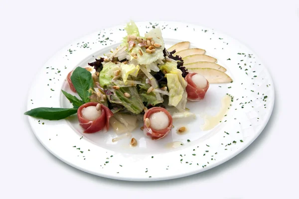 Piatto con insalata, un prosciutto, una pera . — Foto Stock