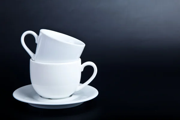Duas xícaras de branco sobre um fundo preto — Fotografia de Stock