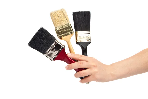 Mão das mulheres Segurando um pincel de três pinturas — Fotografia de Stock