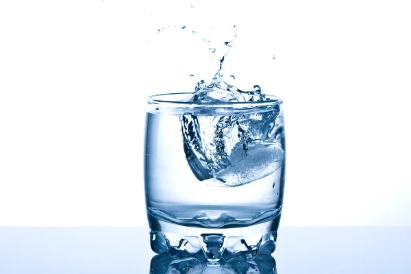 Spetteren in een koele glas water ijs — Stockfoto