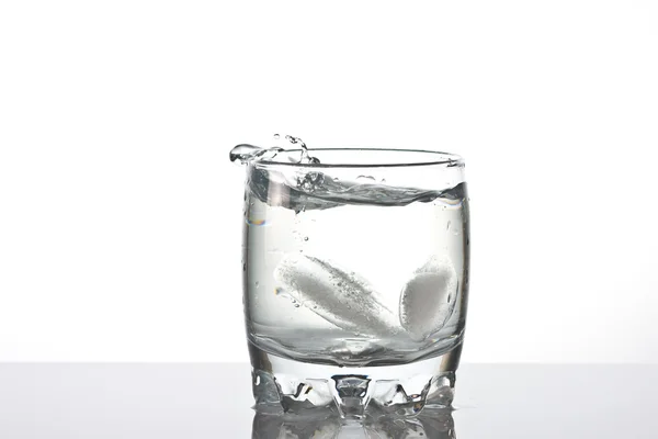 Schot van spetteren in een glas water. — Stockfoto